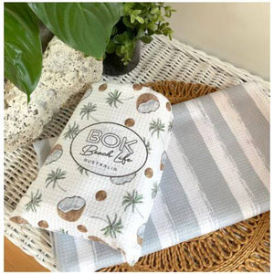 coconut palms sand free towel in its pouch with a second towel showing reverse design