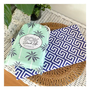 bombora palms beach towel in carry pouch with second towel showing reverse design